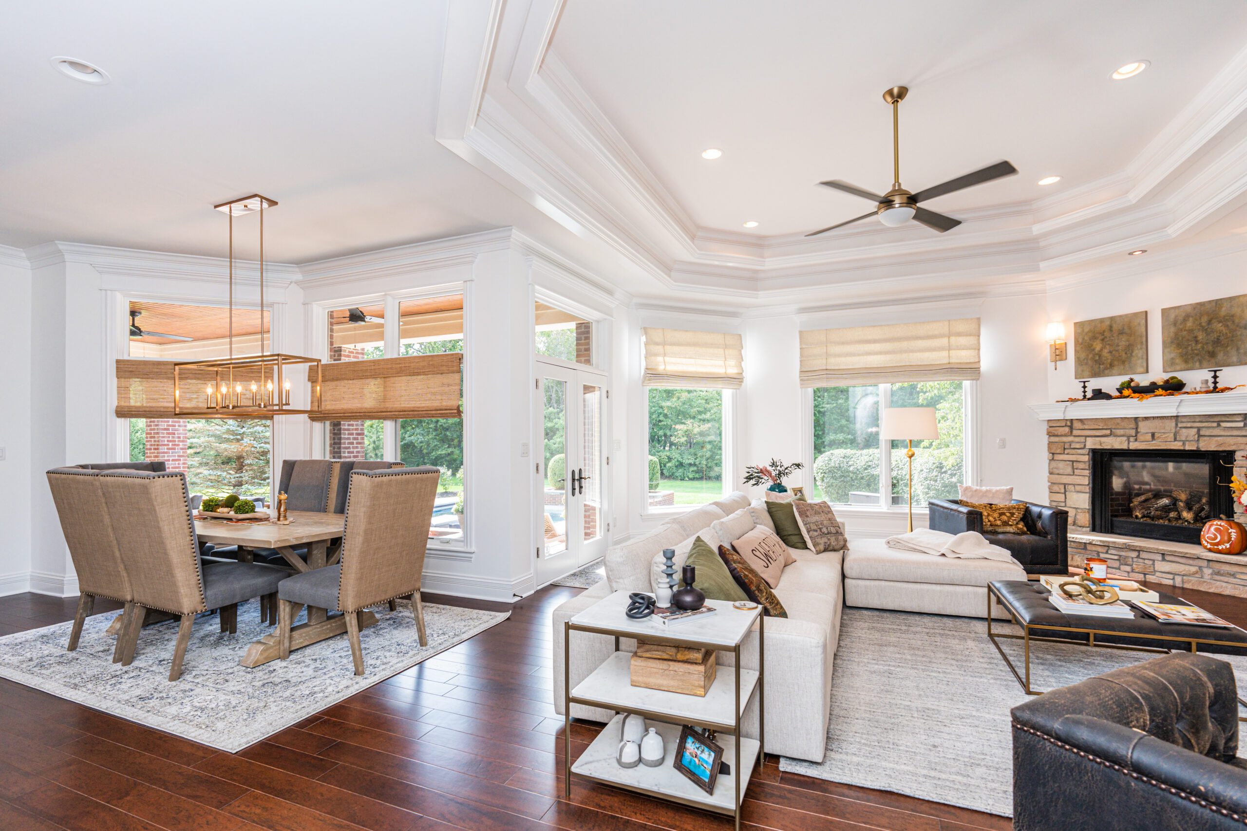 Woven wood shades in dining room and hobbled Roman shades in living room