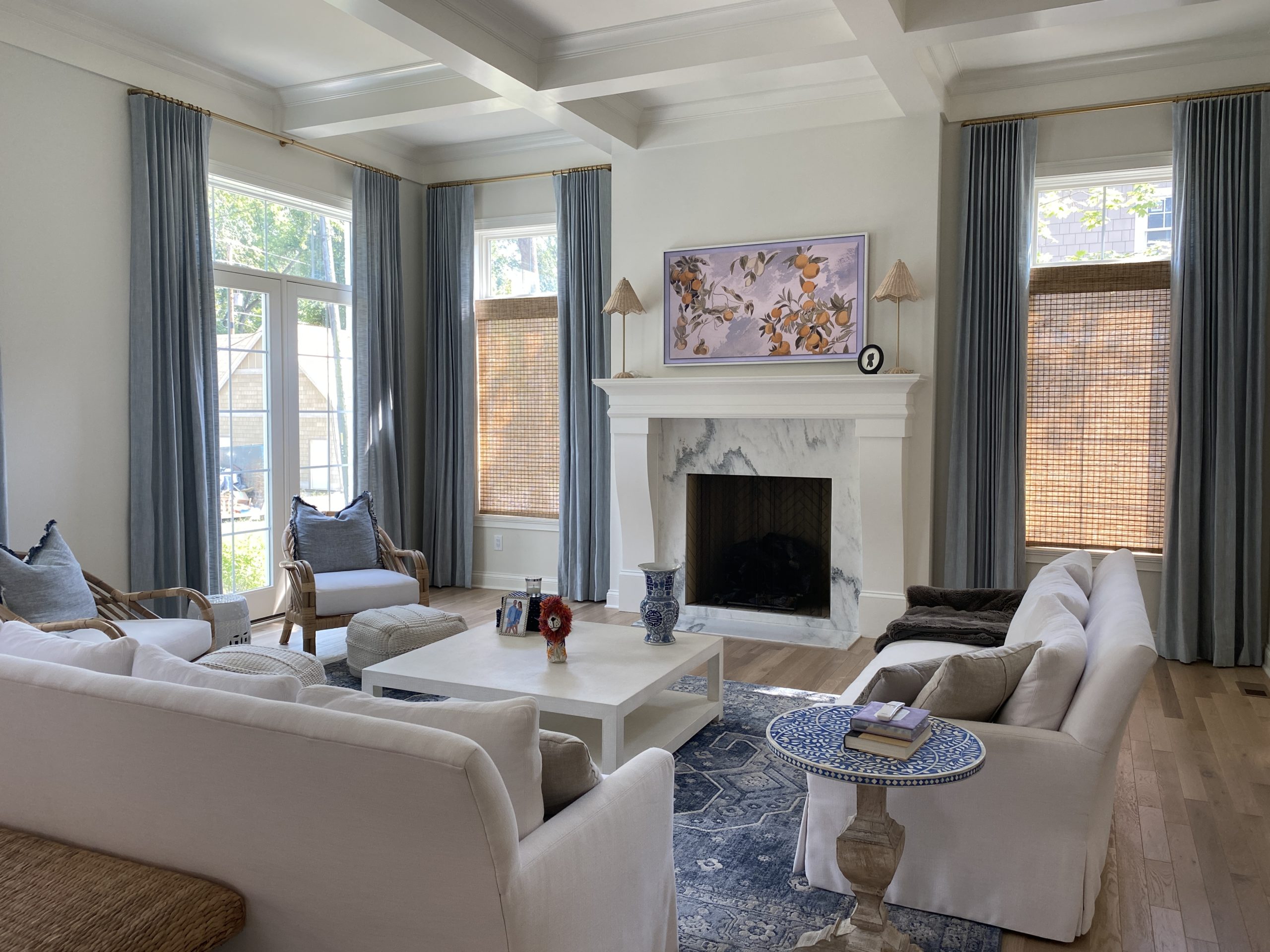 blue drapes layered with woven wood shades in living room