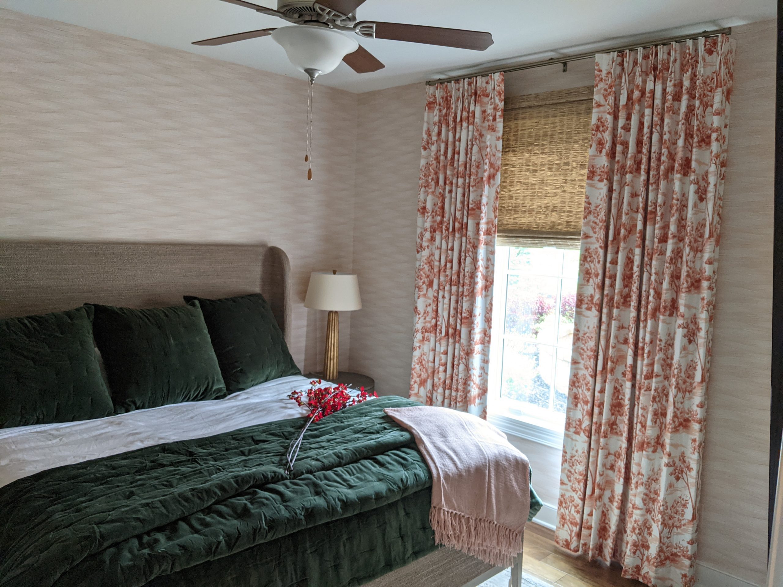 colorful room with drapes and woven wood shades