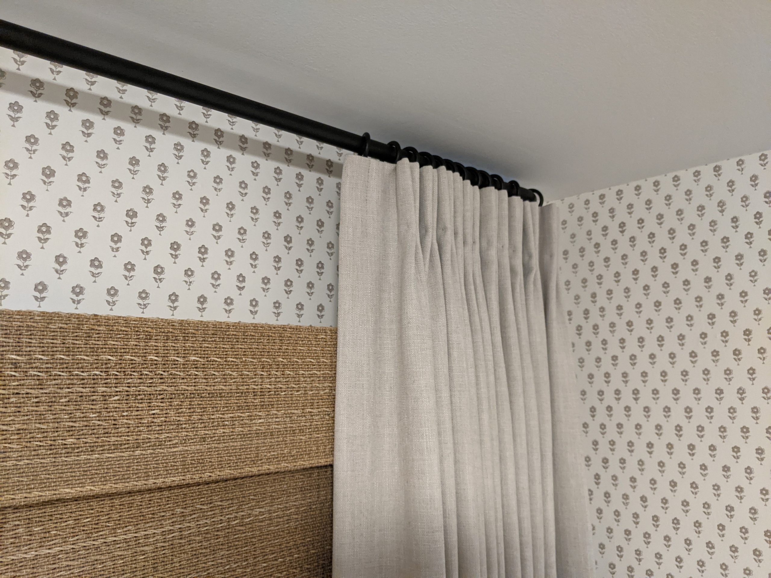 linen drapes over woven shades for added texture